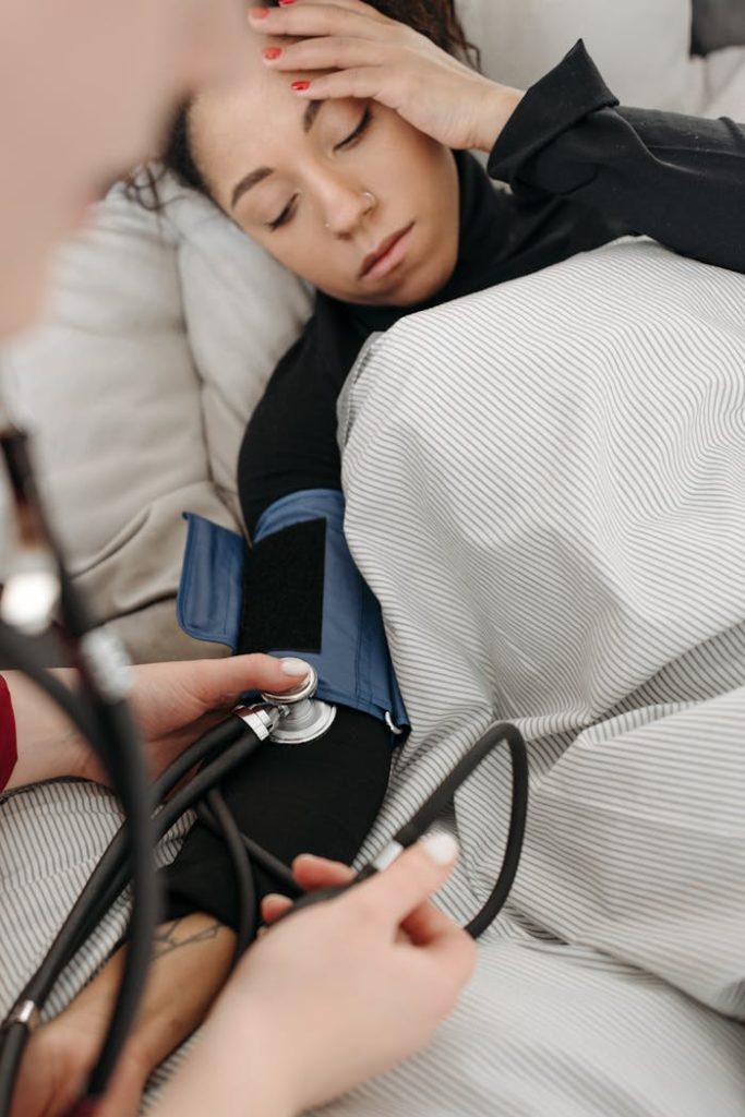 A patient getting her blood pressure checked while resting at home.